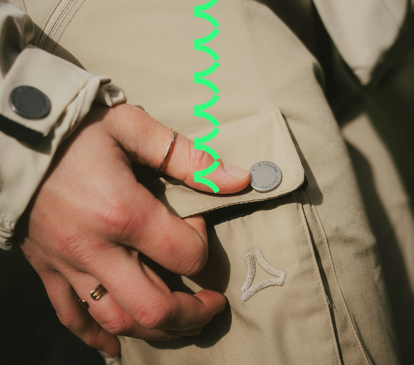 A woman opens the side leg pocket of her trekking trousers.