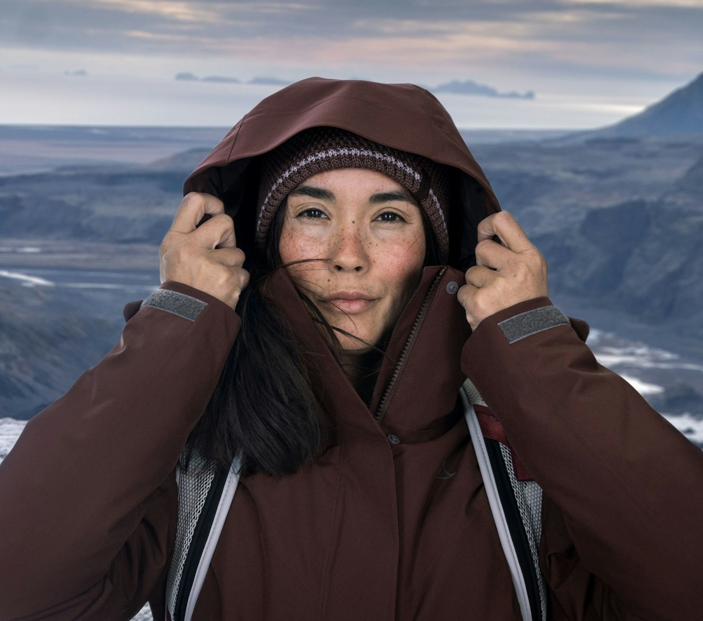 Schöffel Venturi, Frau mit Kapuze und Mütze in Outdoor-Jacke vor rauer Berglandschaft, Schöffel