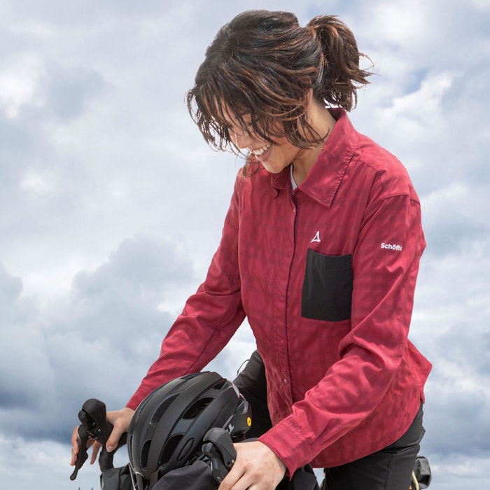 Softshelljacke waschen, Frau in Schöffel-Bluse auf einem Fahrrad am Strand, Schöffel.