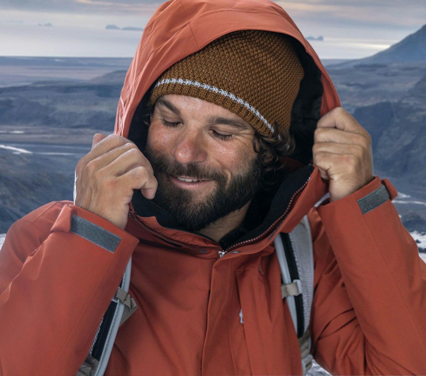 Schöffel Venturi, Mann mit Kapuze und brauner Strickmütze in Outdoor-Jacke vor Berglandschaft, Schöffel.