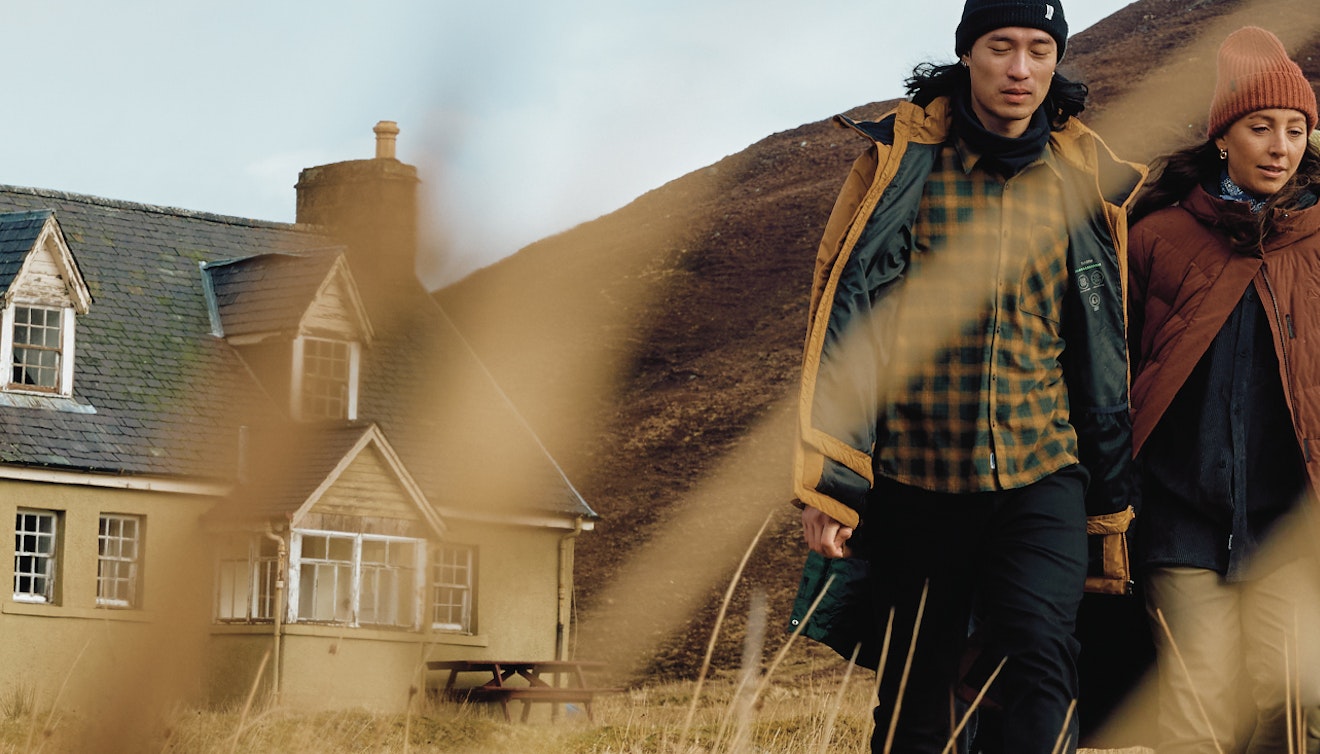 Drei Personen in Schottland vor einem Haus, Schöffel.