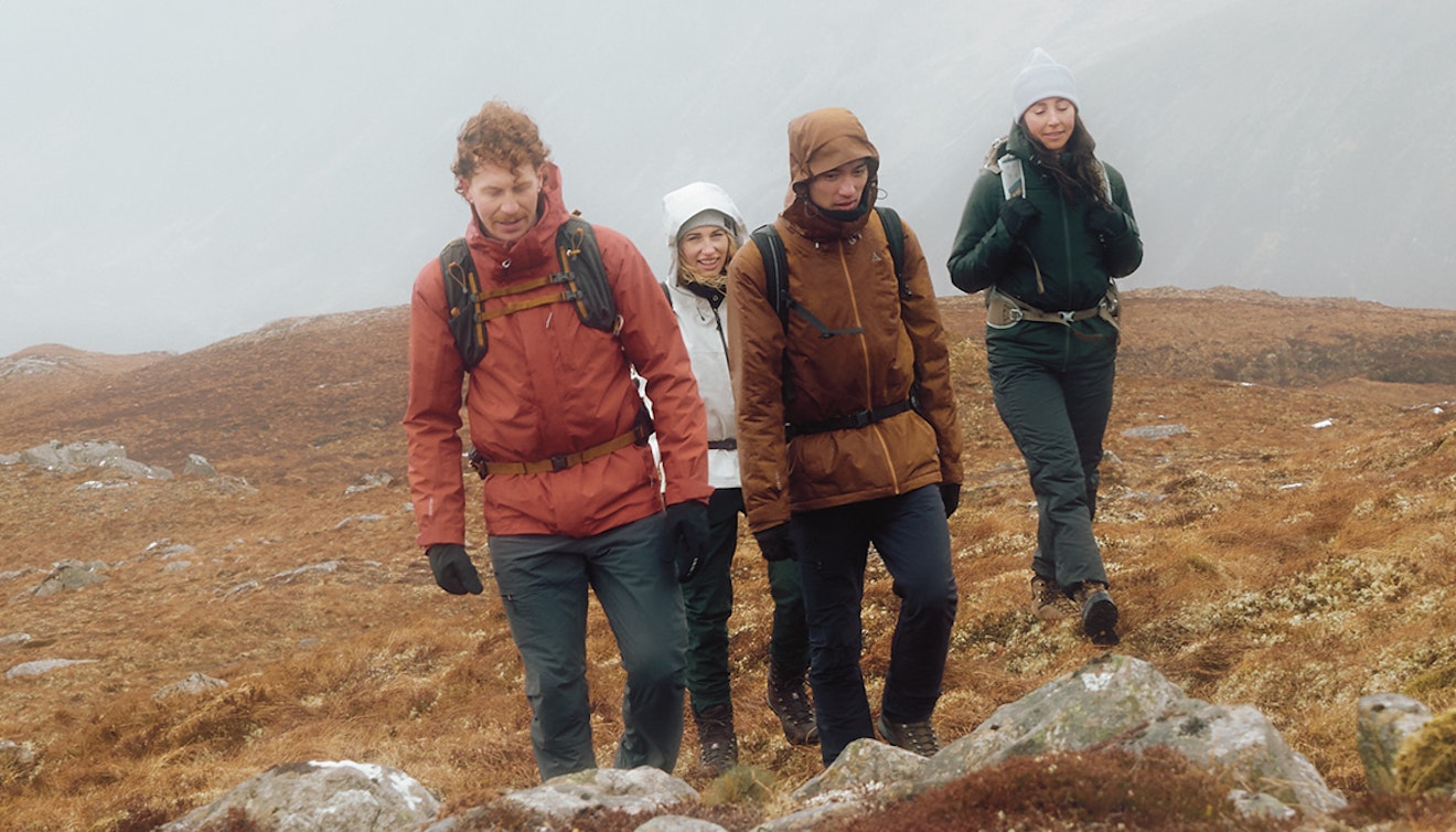 Vier Personen wandern in Schottland einen Berg hinauf, Schöffel.