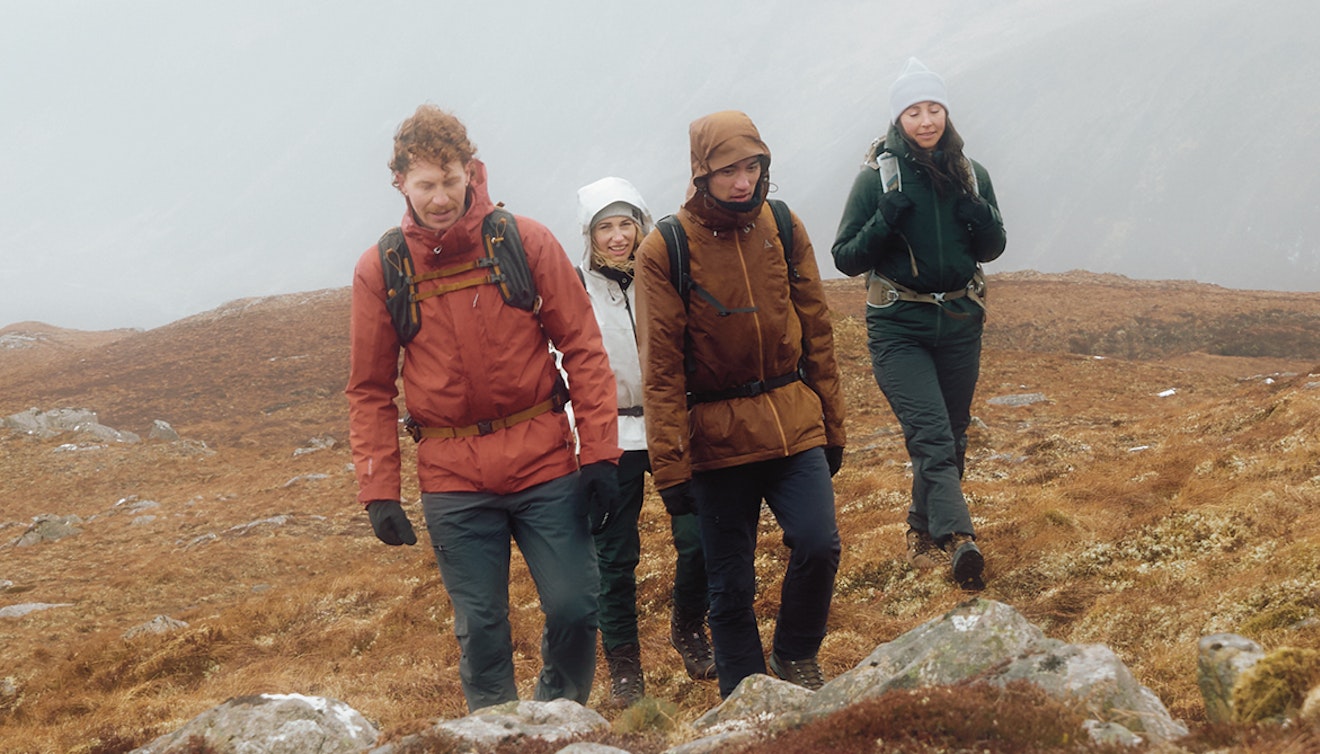 Vier Personen wandern in Schottland einen Berg hinauf, Schöffel.