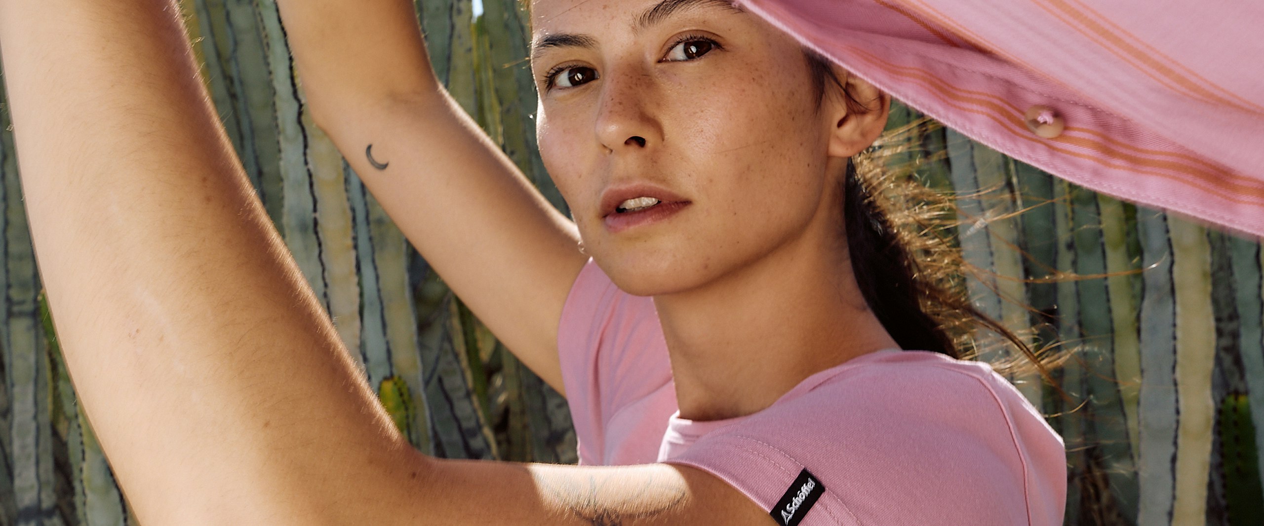 Frau in rosa Shirt mit rosa Fleece - Nahaufnahme in die Kamera 