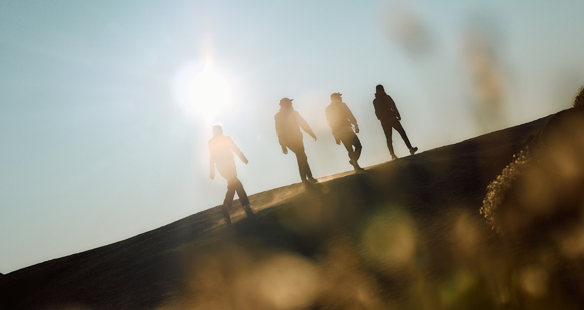 vier Wanderer - bergauf - entspannt - Mittagssonne 