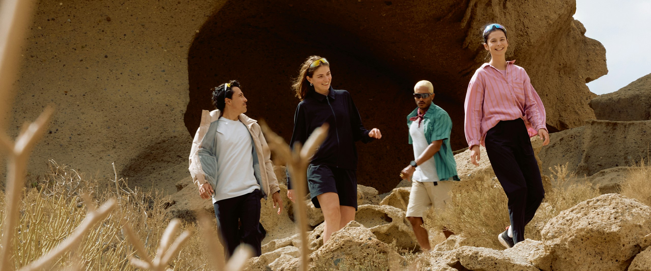 Gruppe von vier Personen in lässiger Kleidung laufen im Sommer