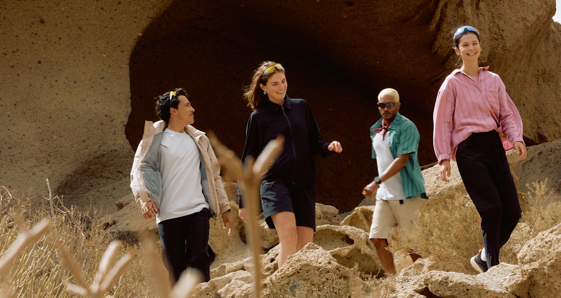 Gruppe von vier Personen in lässiger Kleidung laufen im Sommer