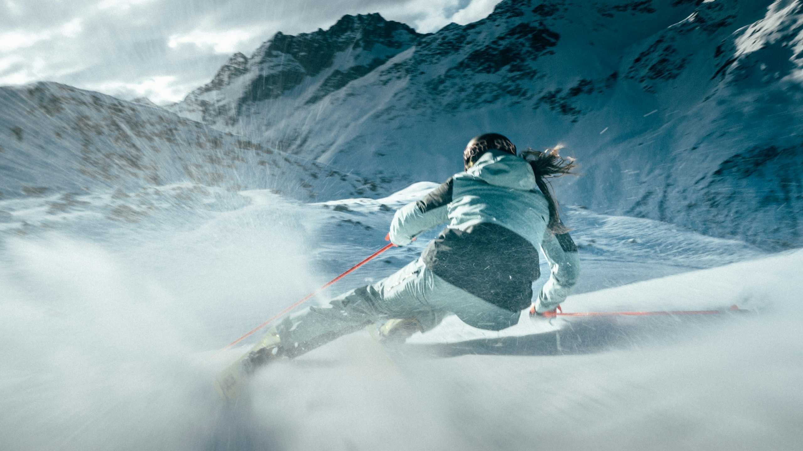 Eine Frau fährt mit Skiern den Berg hinunter, Schöffel.
