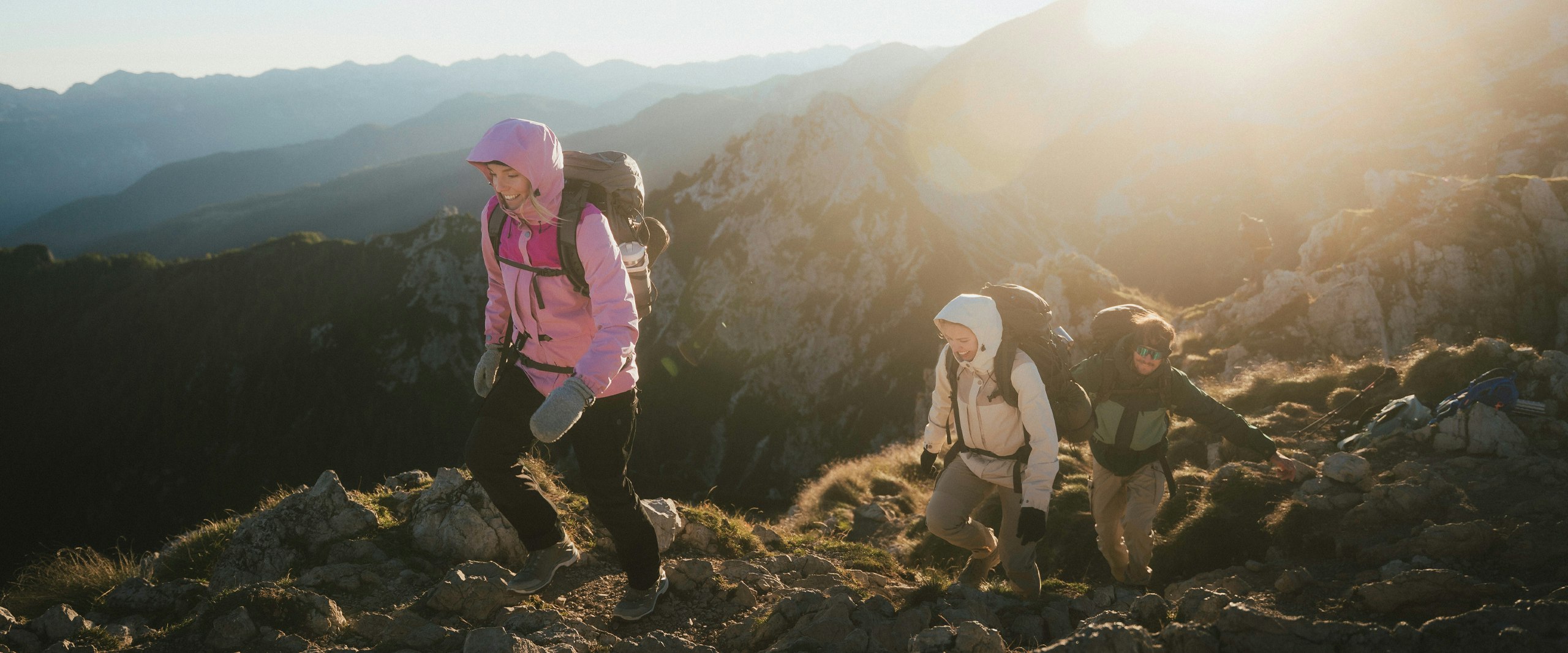Two people are climbing a mountain and can be seen on the ridge.