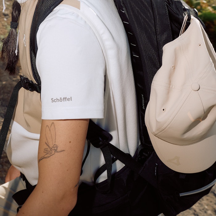 Wanderer sitzt man sieht Details zu Shirt und Cap