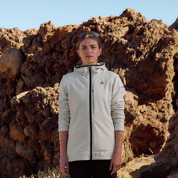 Frau in weißem Fleece steht frontal zur Kamera