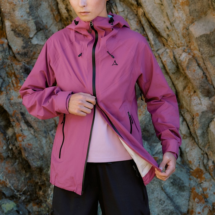 Frau in rosa Fleece und pink Jacke öffnet Jacke von unten nach oben