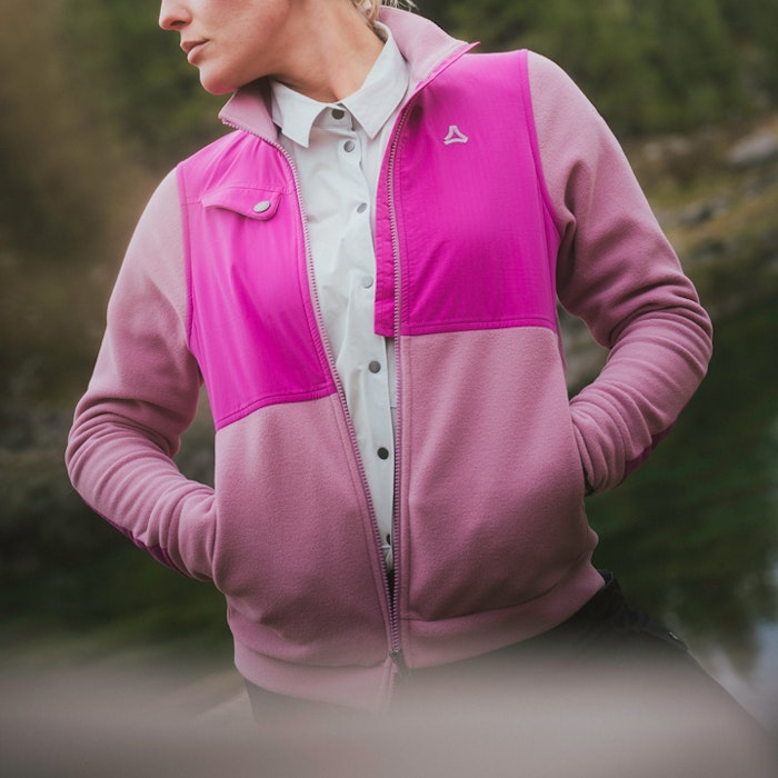 A lady is wearing a pink Schöffel trekking fleece jacket and a light-coloured blouse.