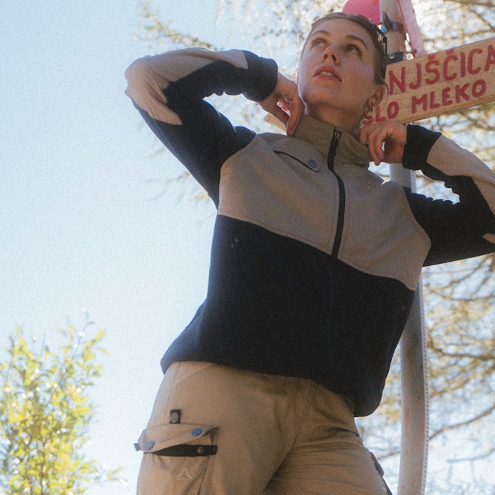 Lady points to the pockets of her trekking trousers with her hands.