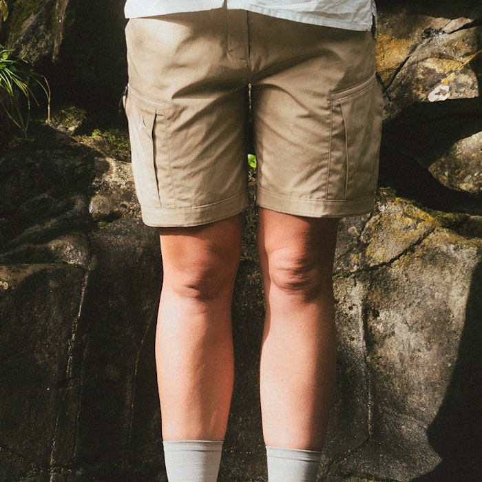 Short trekking trousers worn in front of a stone wall.