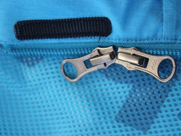 Zwei Reisverschlüsse an blauem Stoff, Schöffel.