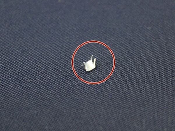 Teil eines Reisverschlusses liegt auf Stoff und ist rot eingekreist, Schöffel.