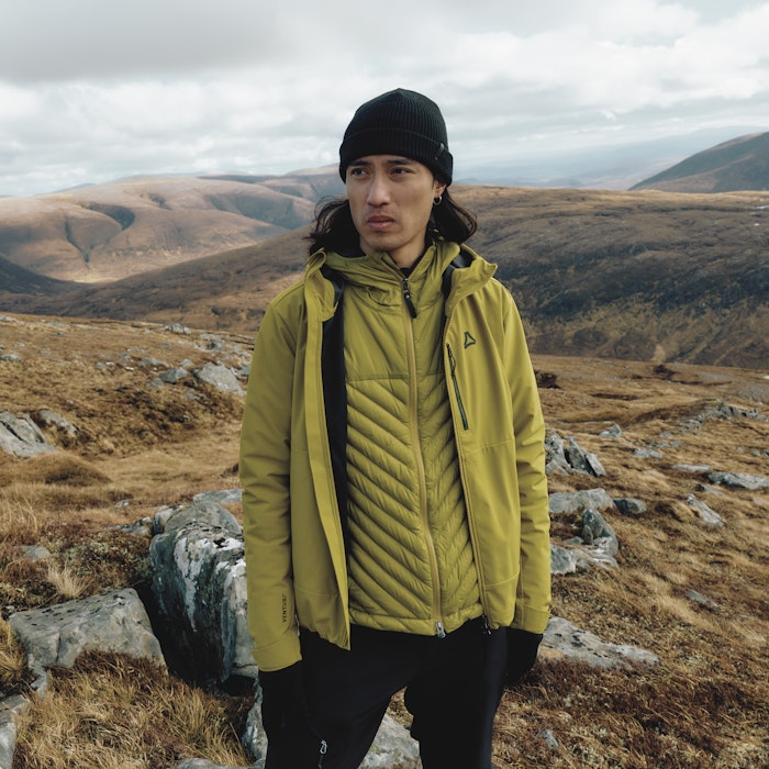 Ein Mann trägt eine gelbe Wanderjacke, Schöffel.