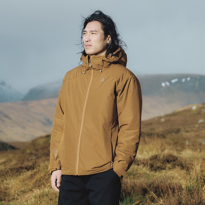 Ein Mann trägt eine gelbe Wanderjacke, Schöffel.