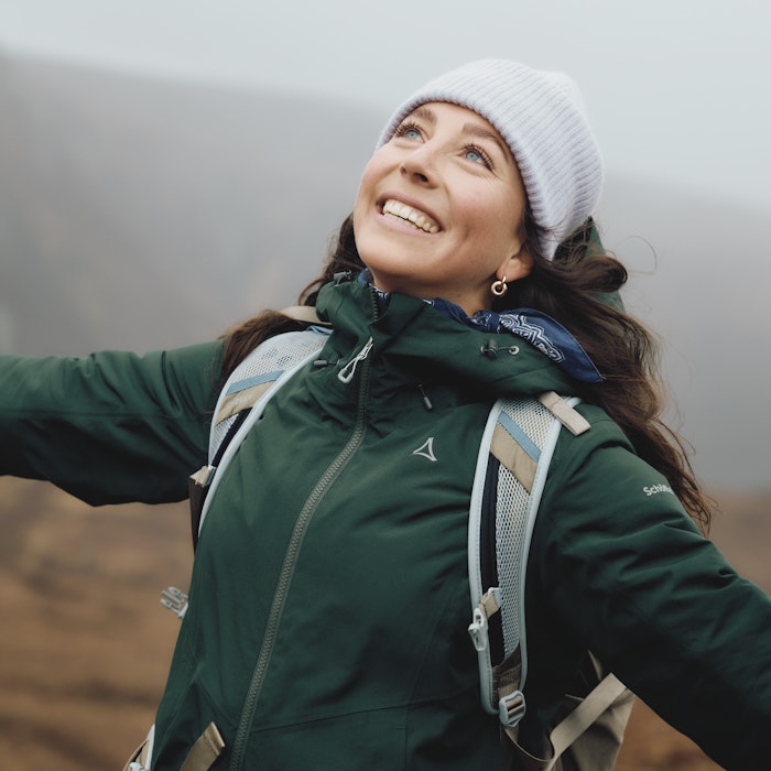 Eine Frau trägt eine dunkelgrüne Jacke, Schöffel.