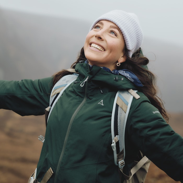 Eine Frau trägt eine dunkelgrüne Jacke, Schöffel.
