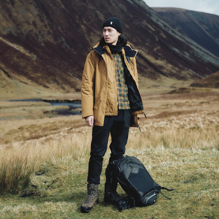 Ein Mann trägt eine gelbe Wanderjacke, Schöffel.