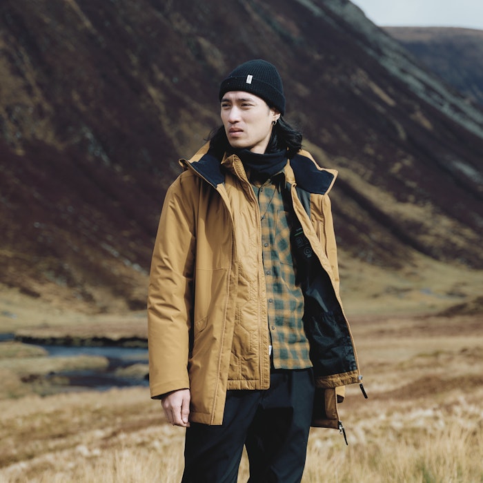 Ein Mann trägt eine gelbe Wanderjacke, Schöffel.