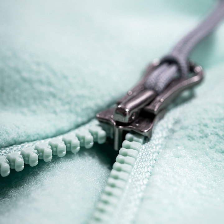 Reißverschluss reparieren, Nahaufnahme eines Kunststoffzippers auf mintgrünem Fleece, Schöffel.